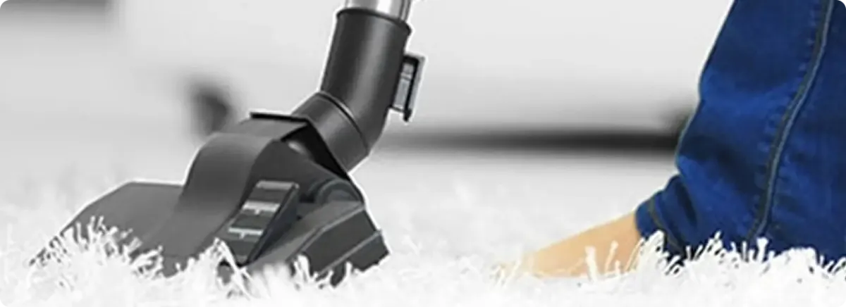 Close-up of a professional vacuuming a white carpet in Whites Creek.